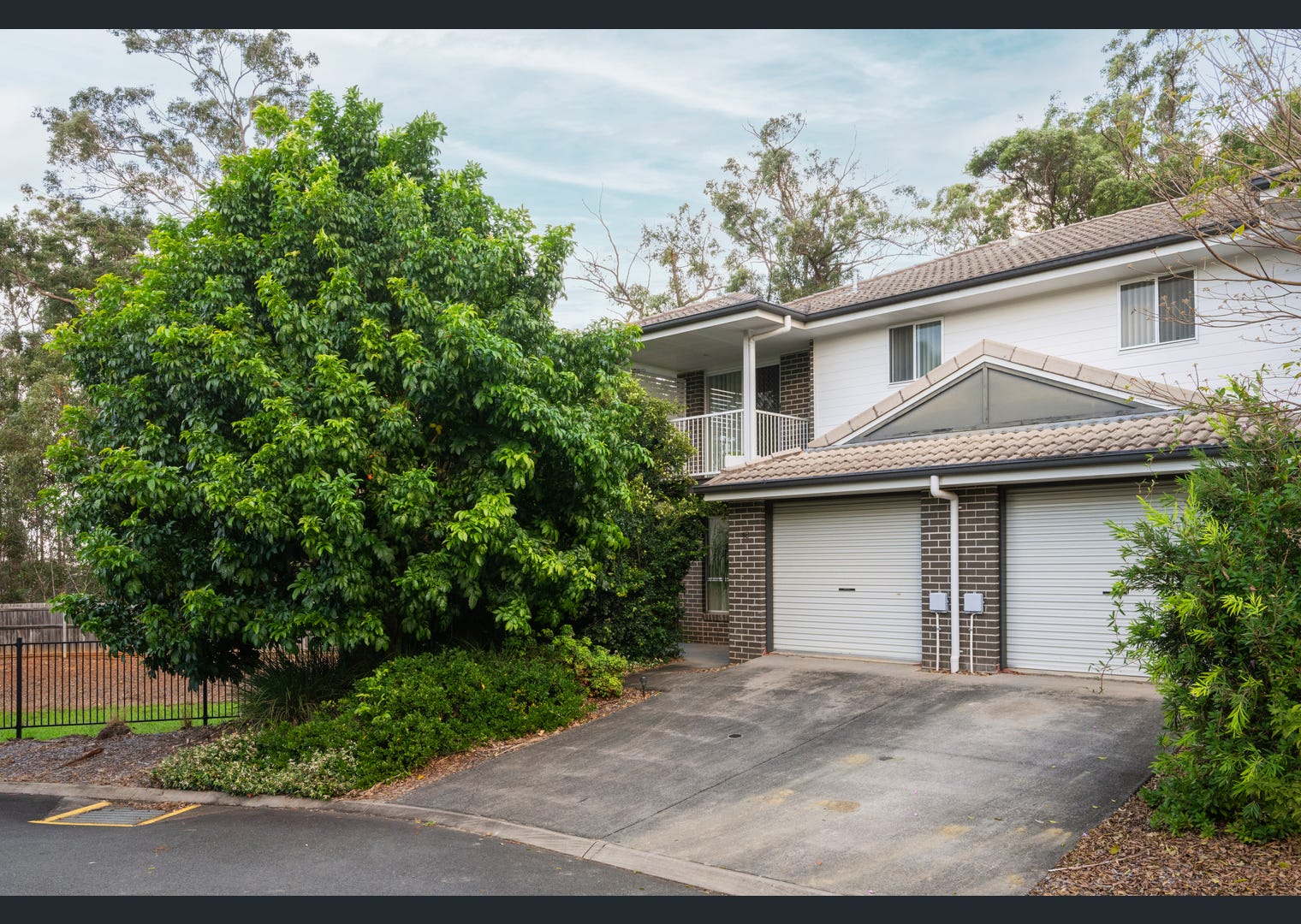 The townhouse purchased for the client, with its garage and landscaped frontage